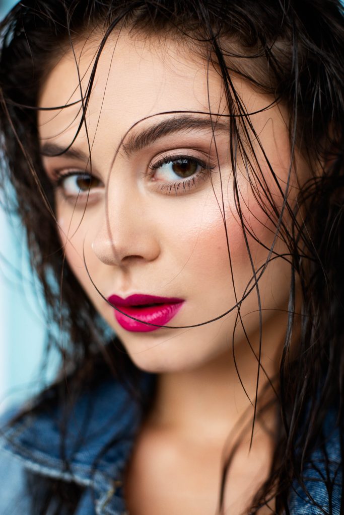 Sexy model with dark hair, magenta lipstick, perfect eyebrows, and wet hair
